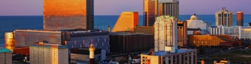 City skyline with tall buildings glowing in golden sunset light.