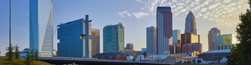 Modern city skyline with tall buildings under a bright sky.