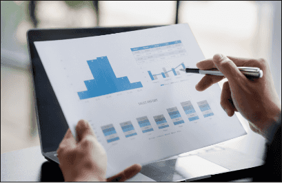 Person reviewing a printed performance report with blue charts.
