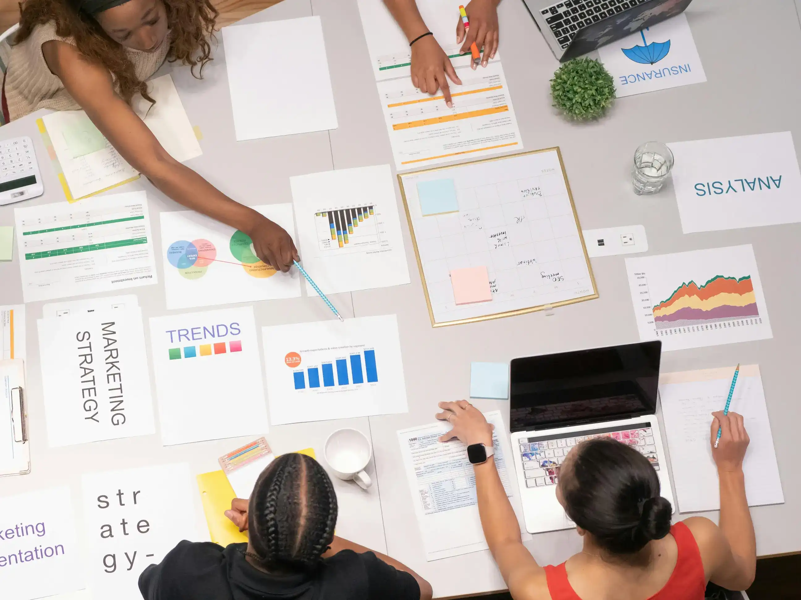 Team planning marketing strategy with charts, reports and notes.