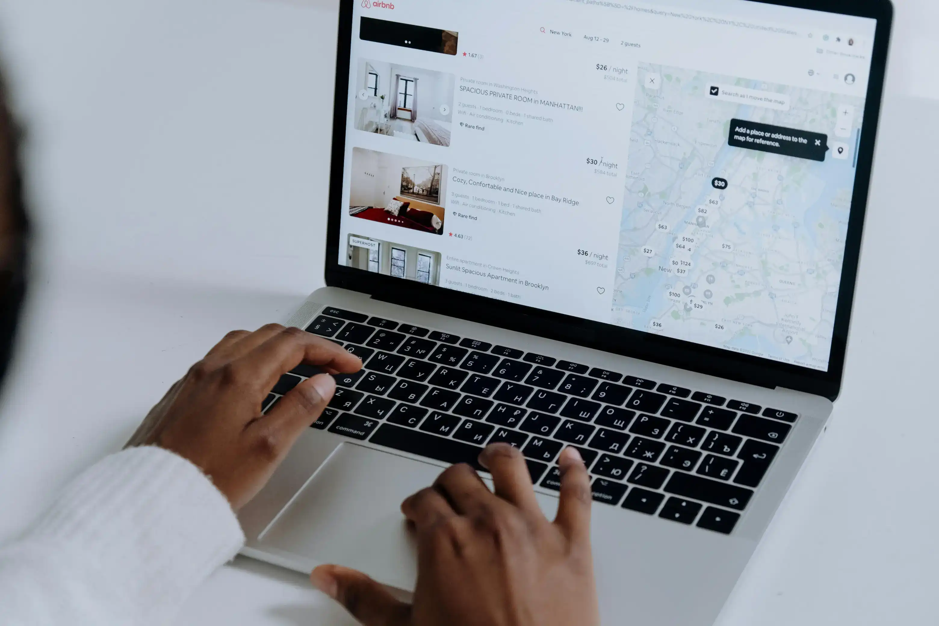 Person searching rental listings on a laptop with a map view.